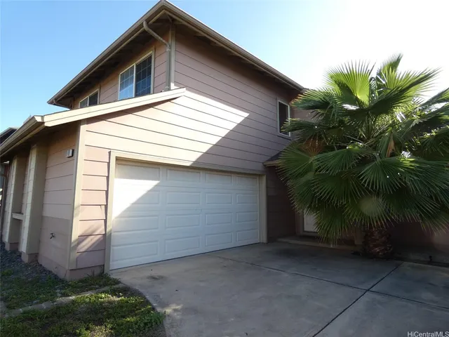 a view of house with a yard and garage
