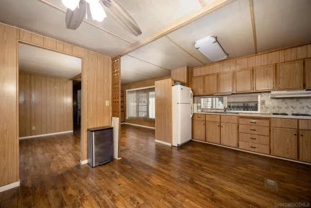 a kitchen with granite countertop a refrigerator and microwave
