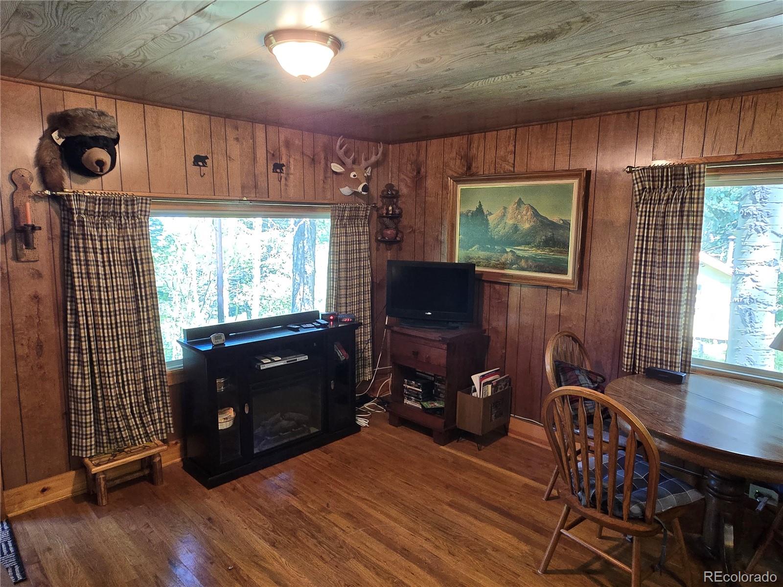 9626 Highway 165 Rye, CO 81069 - Photo 13 of 27 a living room with furniture a flat screen tv and floor to ceiling window