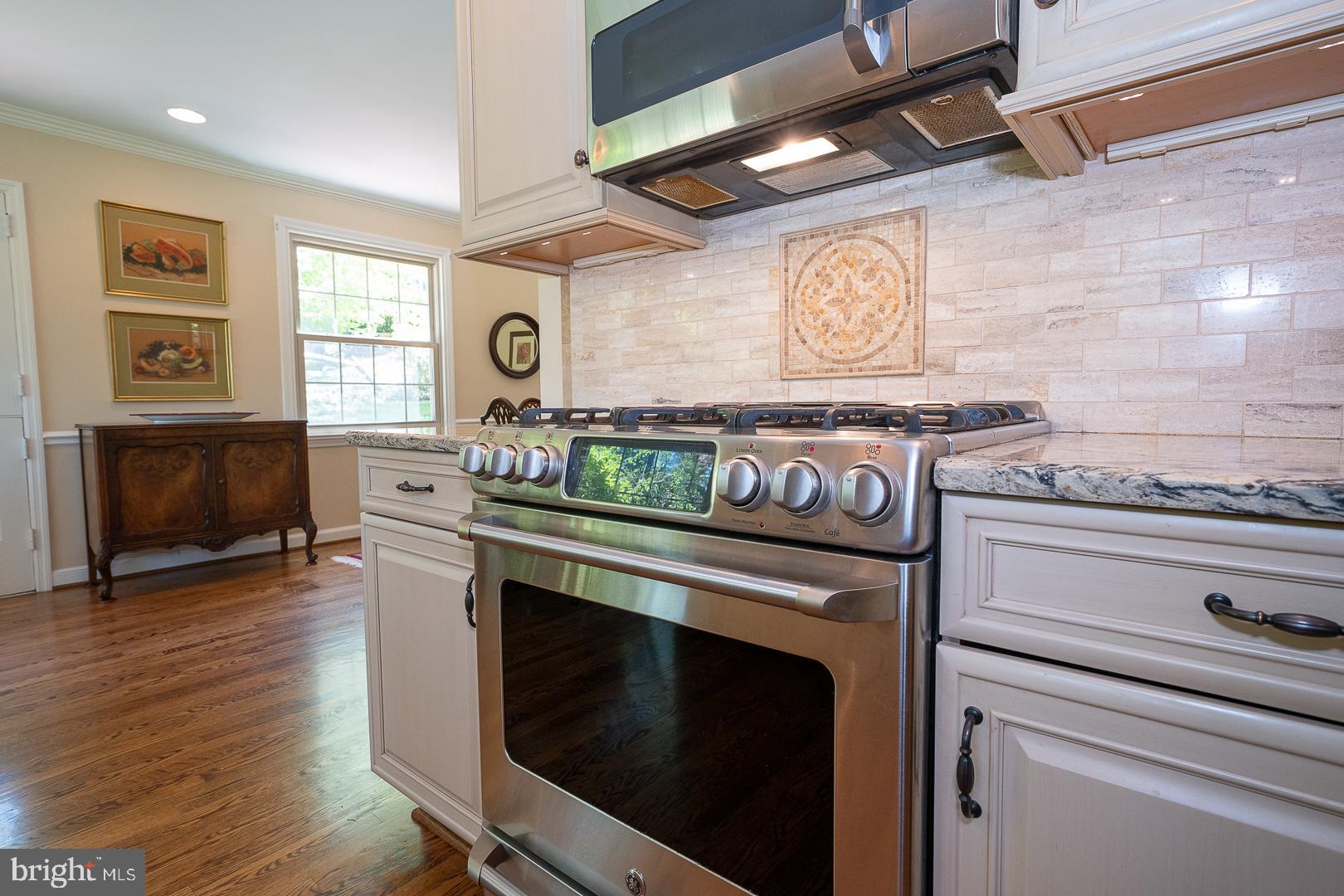 658 Conestoga Road Villanova, PA 19085 - Photo 15 of 57 a kitchen with granite countertop a stove and a wooden floor