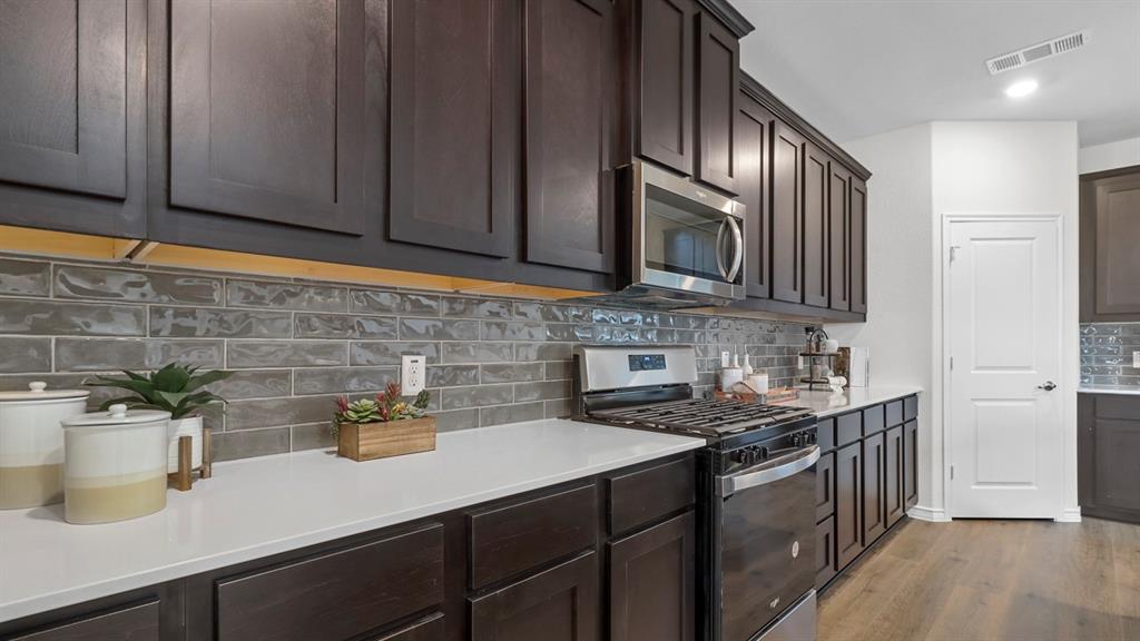 2000 Foggy Wds Lane Anna, TX 75409 - Photo 21 of 40 a kitchen with stainless steel appliances granite countertop a sink stove and cabinets