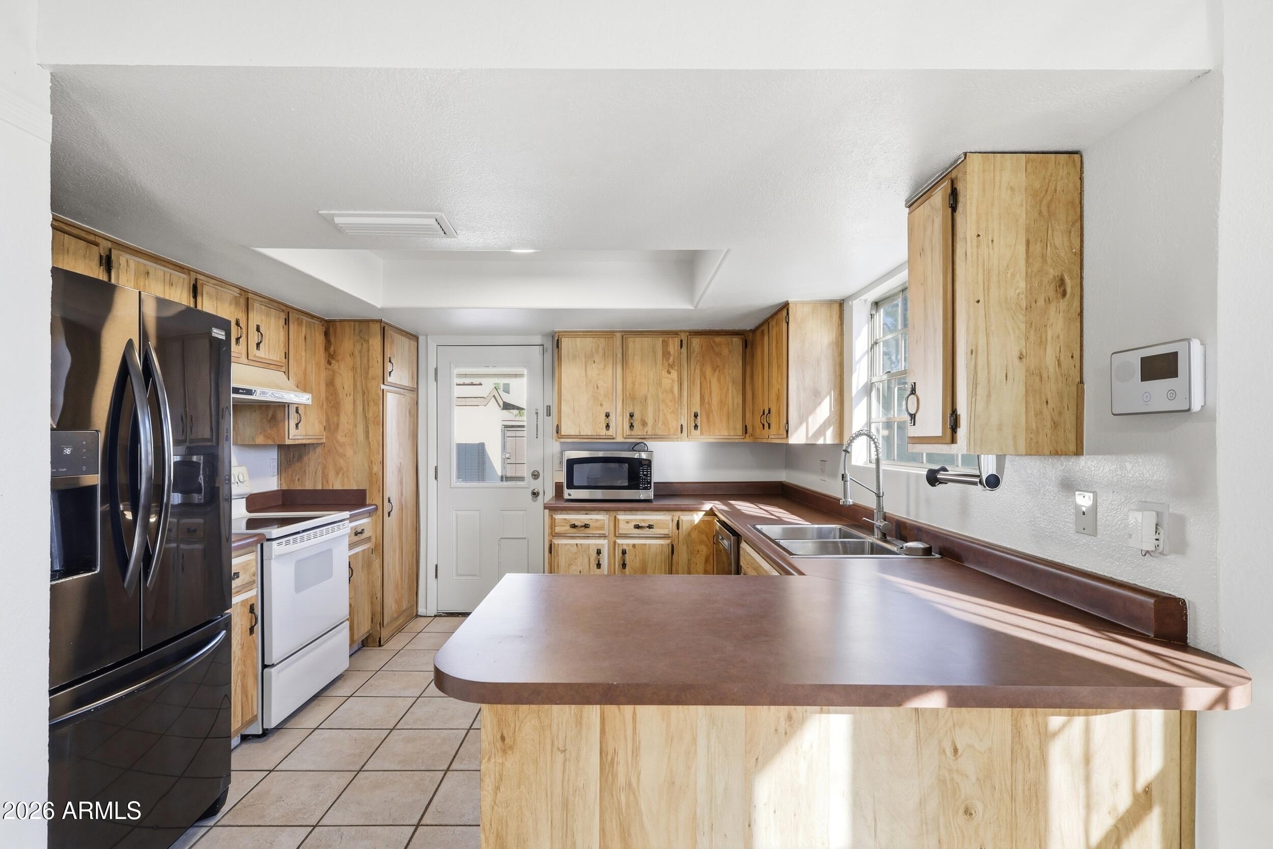 1033 East Bendix Drive Tempe, AZ 85283 - Photo 12 of 31 a kitchen with stainless steel appliances granite countertop a sink refrigerator and cabinets
