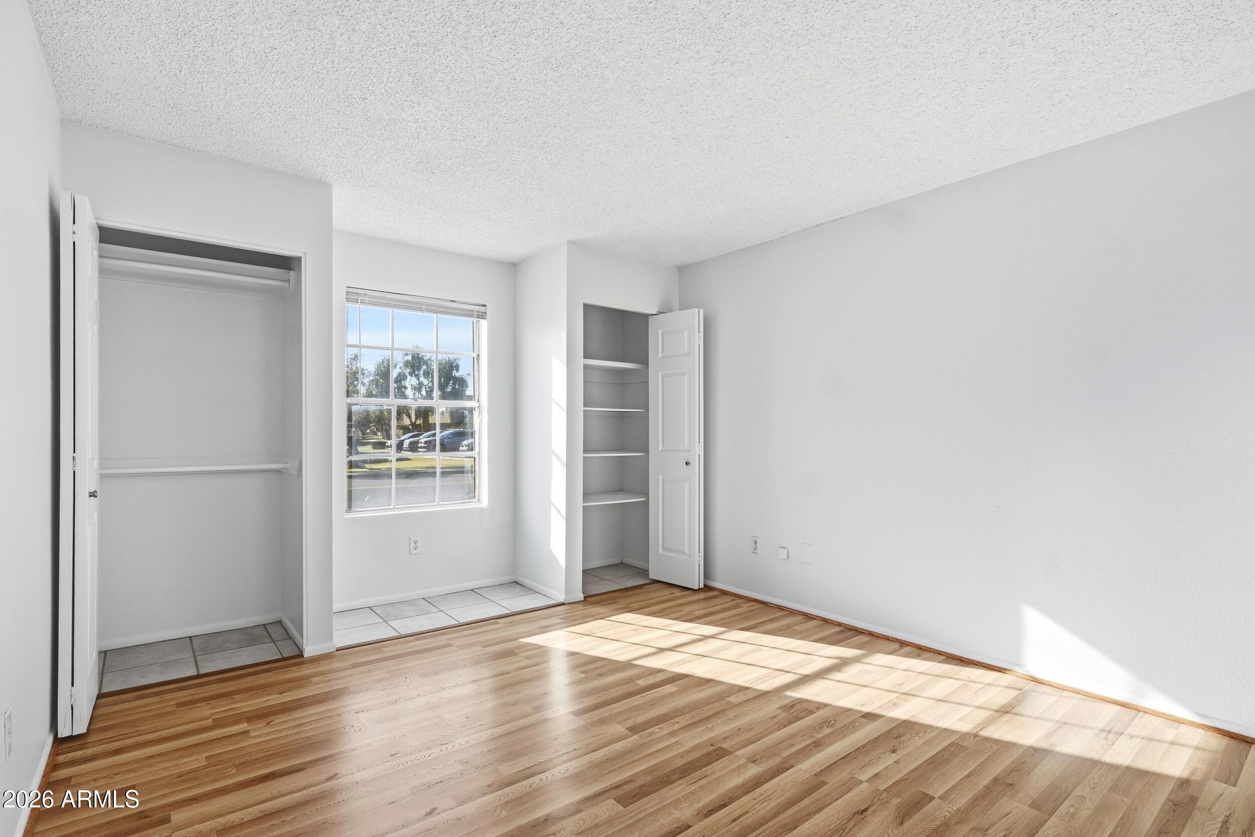 1033 East Bendix Drive Tempe, AZ 85283 - Photo 16 of 31 an empty room with wooden floor and windows