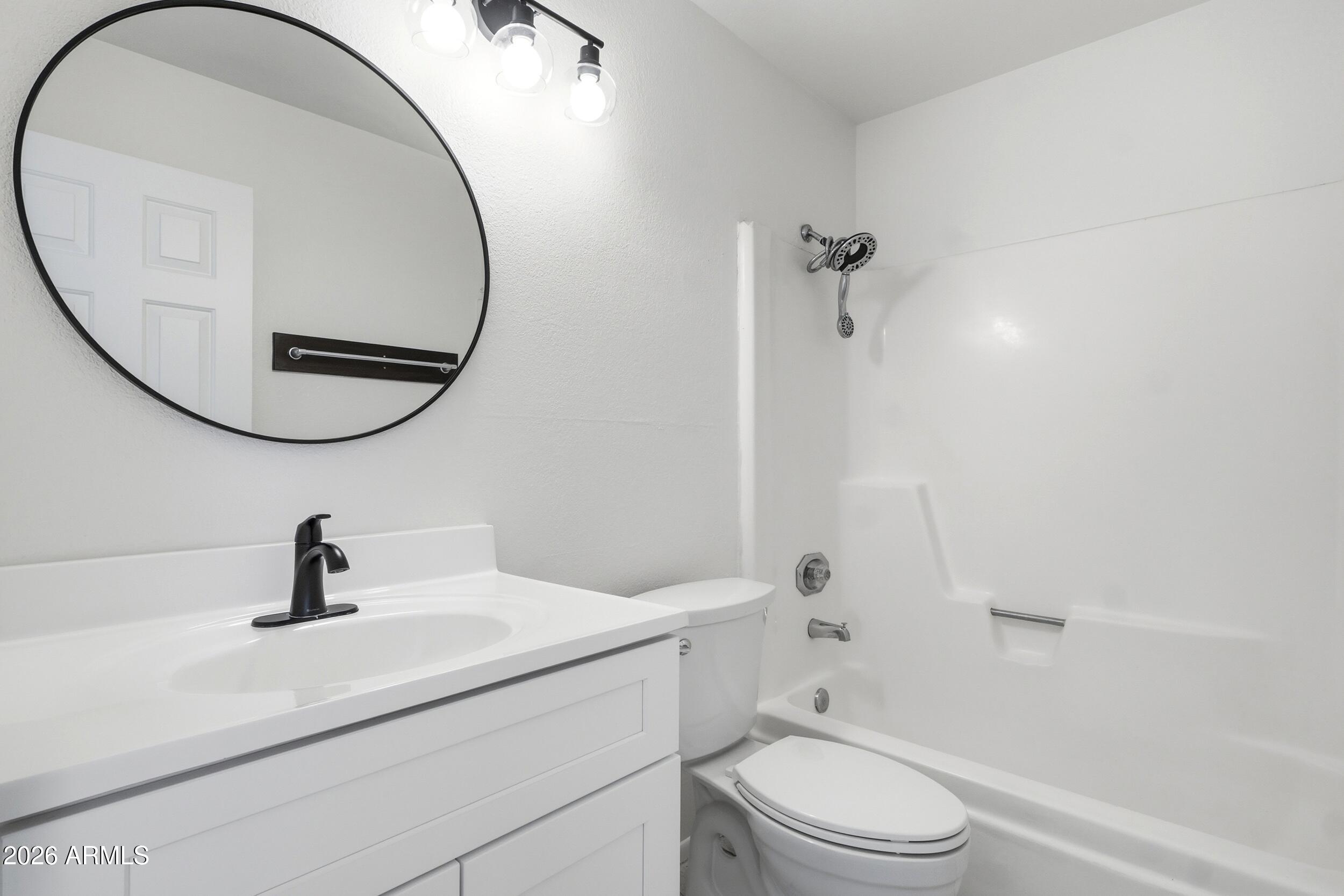 1033 East Bendix Drive Tempe, AZ 85283 - Photo 20 of 31 a bathroom with a sink a toilet and a mirror