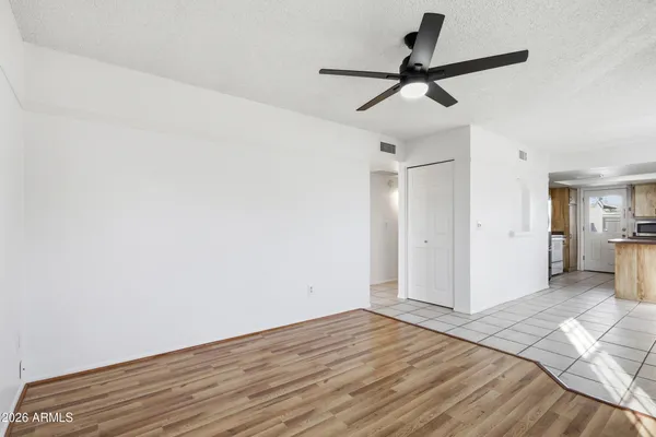 a view of a kitchen with wooden floor and a ceiling fan