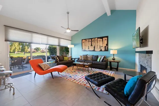 a living room with furniture a flat screen tv and a large window