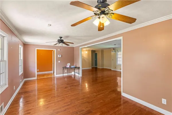 a view of an empty room with a window and wooden floor