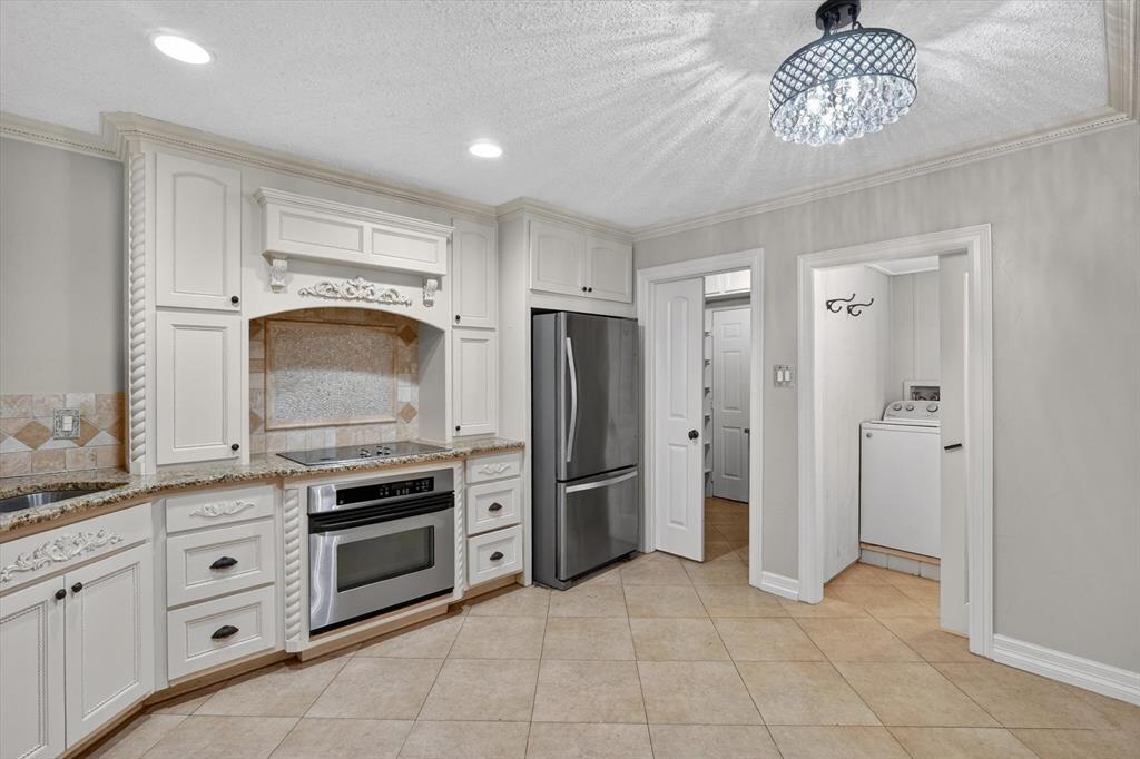 272 Lodge Road Coppell, TX 75019 - Photo 2 of 24 a kitchen with cabinets stainless steel appliances and a counter top space