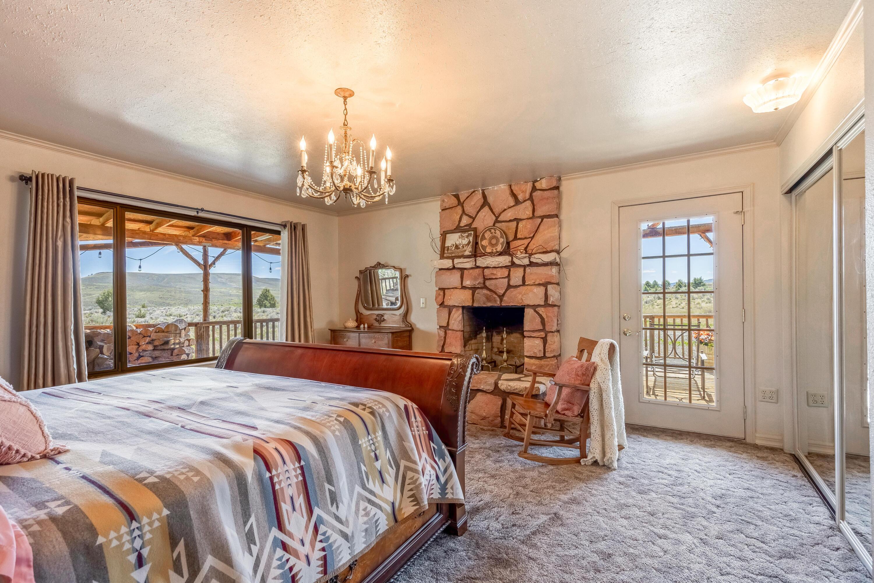 25887 Weberg Road Paulina, OR 97751 - Photo 10 of 46 a bedroom with a bed and a chandelier