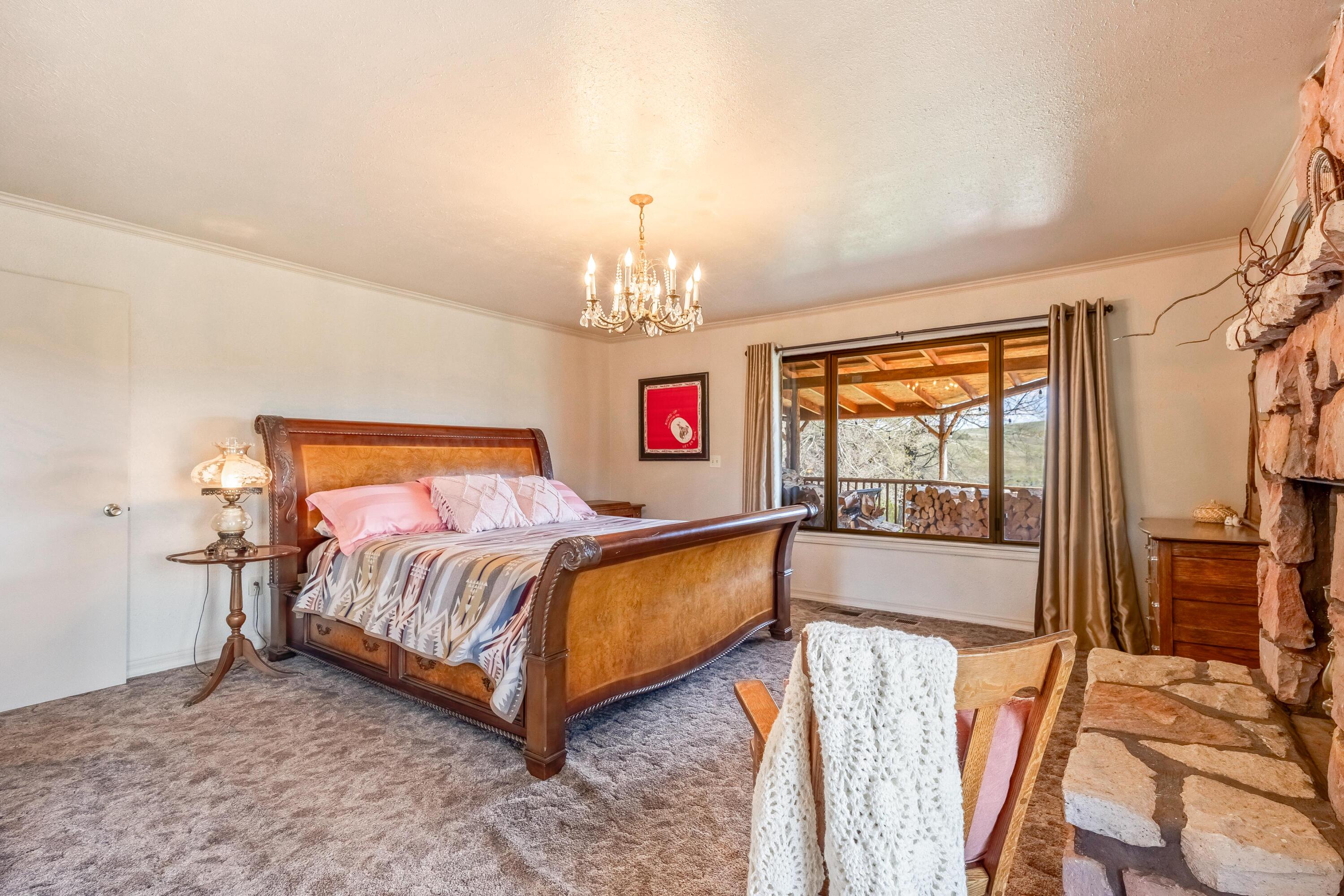 25887 Weberg Road Paulina, OR 97751 - Photo 11 of 46 a bedroom with a bed and a chandelier