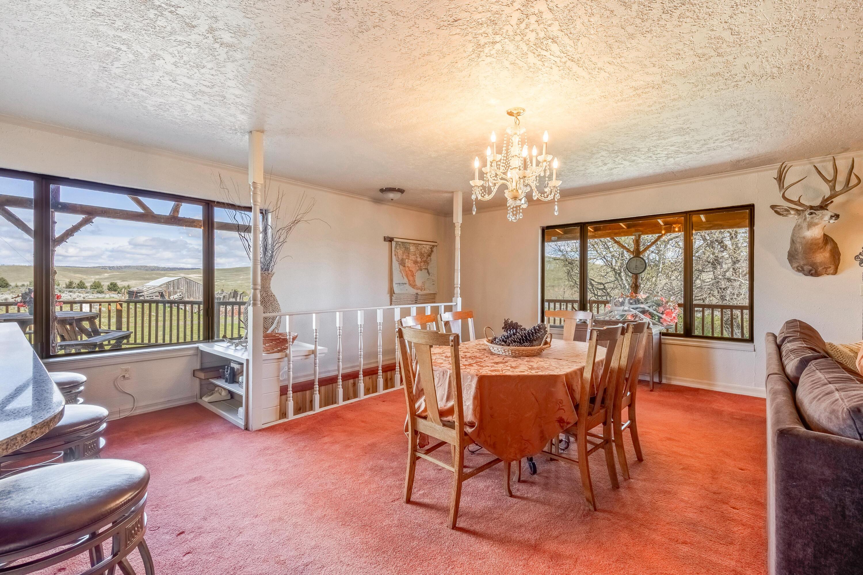 25887 Weberg Road Paulina, OR 97751 - Photo 6 of 46 a view of a dining room with furniture large windows and wooden floor