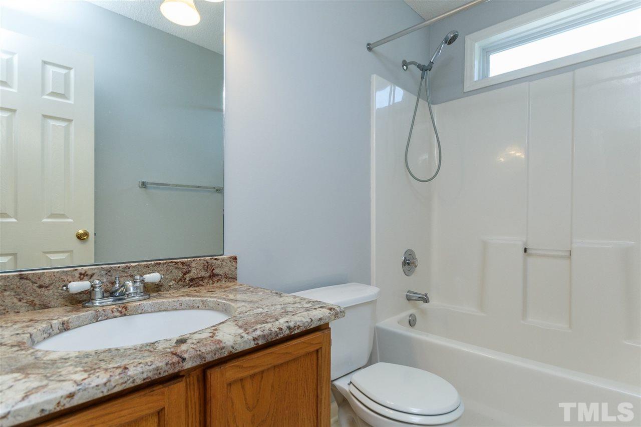 5006 Gable Ridge Drive Durham, NC 27713 - Photo 19 of 24 a bathroom with a granite countertop sink toilet bathtub and shower