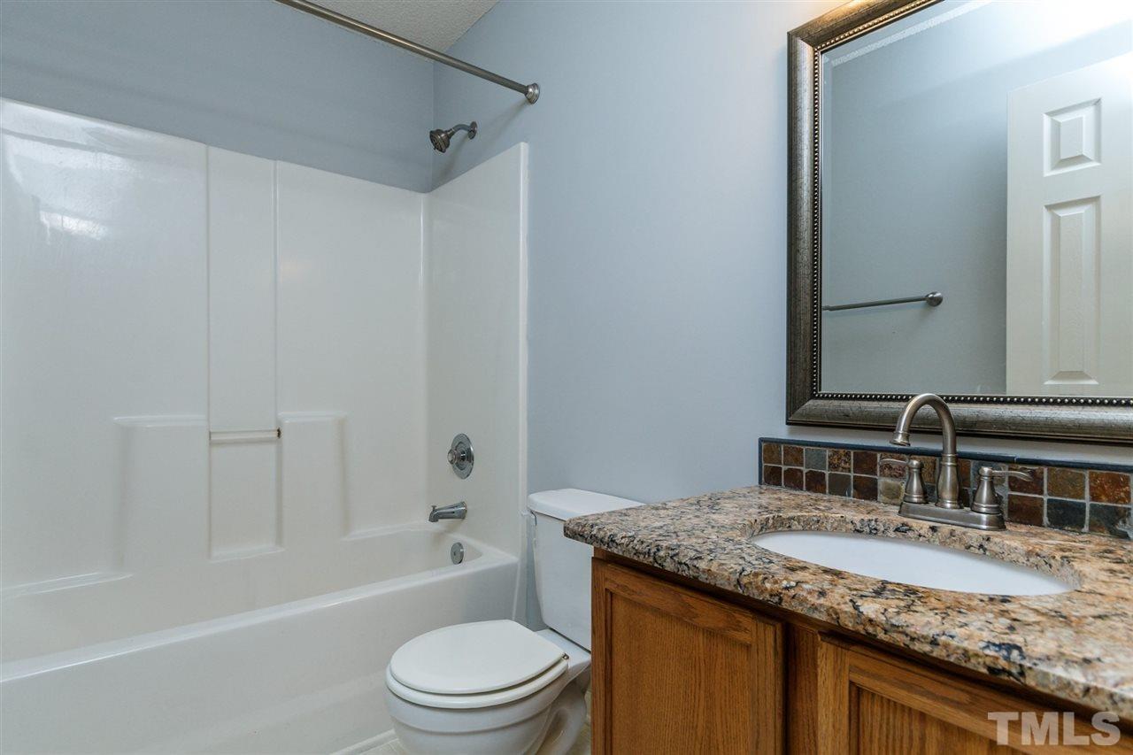 5006 Gable Ridge Drive Durham, NC 27713 - Photo 20 of 24 a bathroom with a granite countertop sink toilet and shower