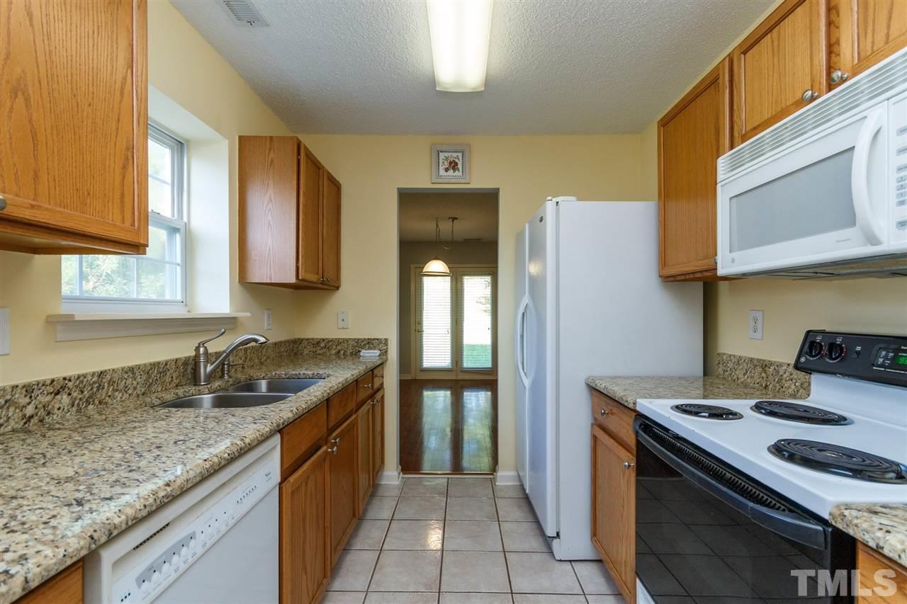 5006 Gable Ridge Drive Durham, NC 27713 - Photo 7 of 24 a kitchen with granite countertop a sink stove and refrigerator