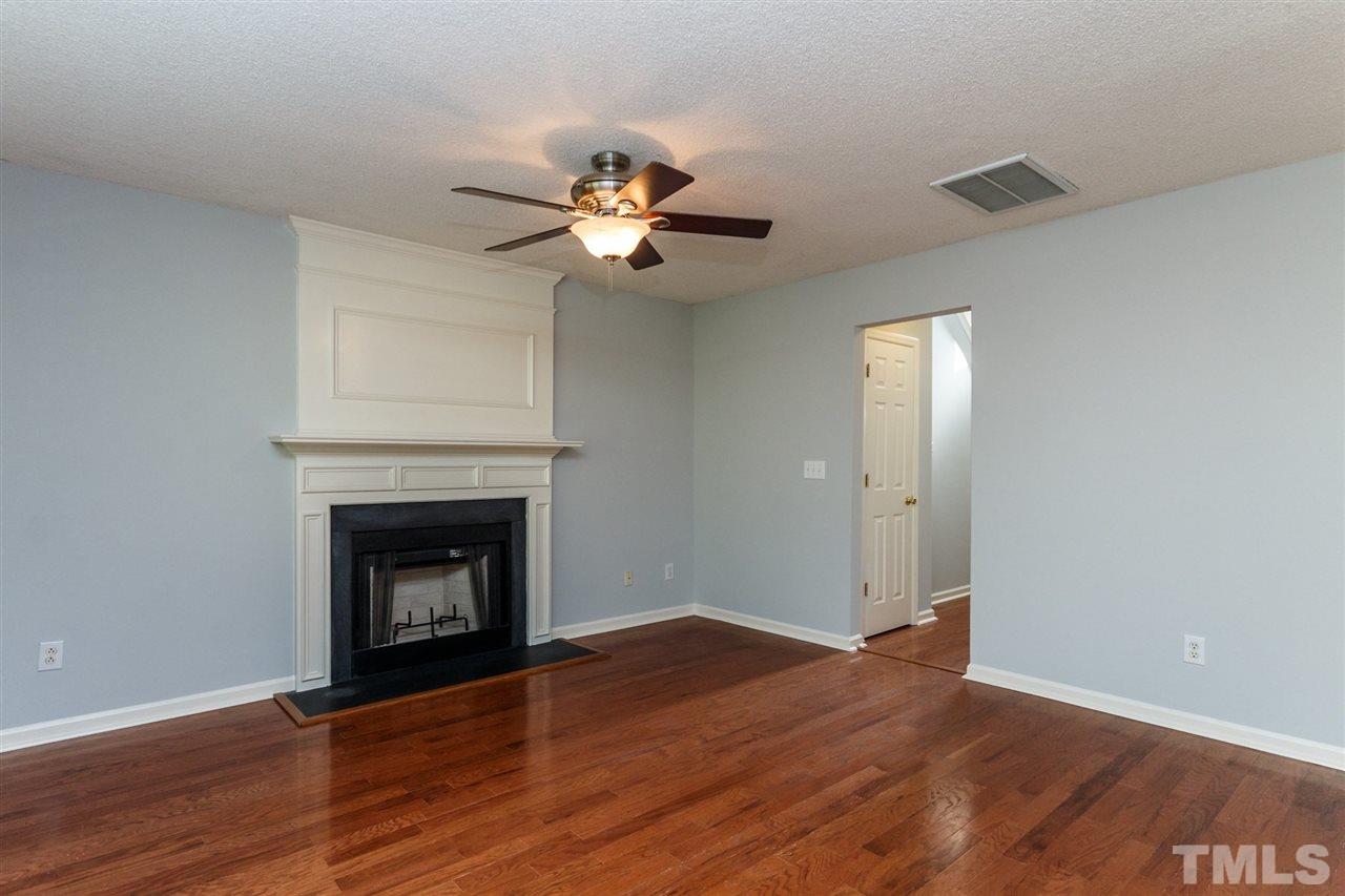 5006 Gable Ridge Drive Durham, NC 27713 - Photo 8 of 24 a view of an empty room with wooden floor and a fireplace