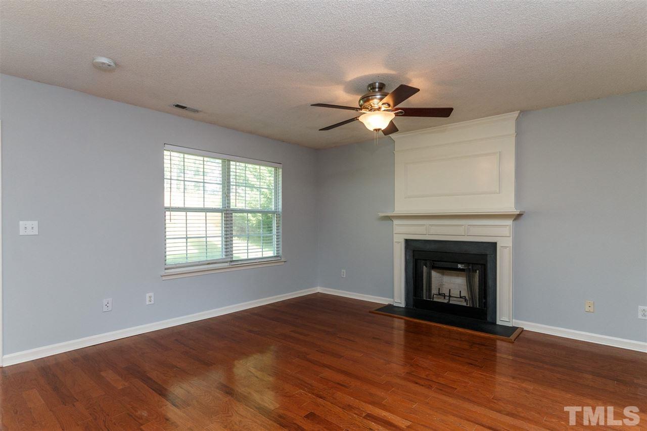 5006 Gable Ridge Drive Durham, NC 27713 - Photo 9 of 24 an empty room with wooden floor fireplace and a window