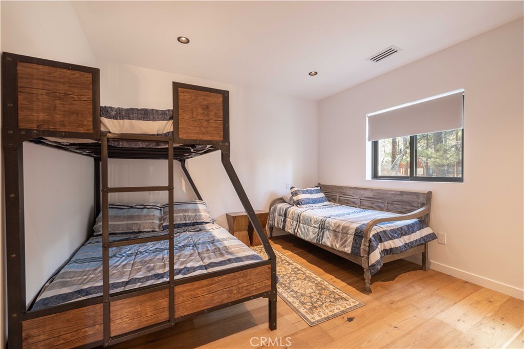 259 Victoria Sugarloaf, CA 92386 - Photo 22 of 32 a bedroom with a bed and wooden floor