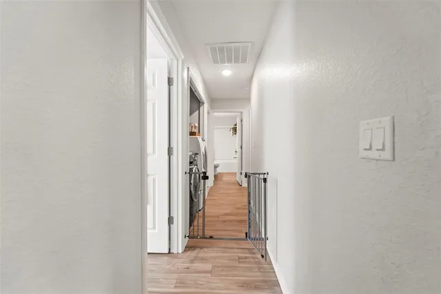 a dining room with stainless steel appliances a dining table wooden floor and a view of kitchen