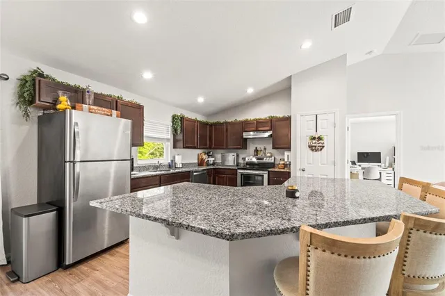 a kitchen with stainless steel appliances granite countertop a stove sink and cabinets