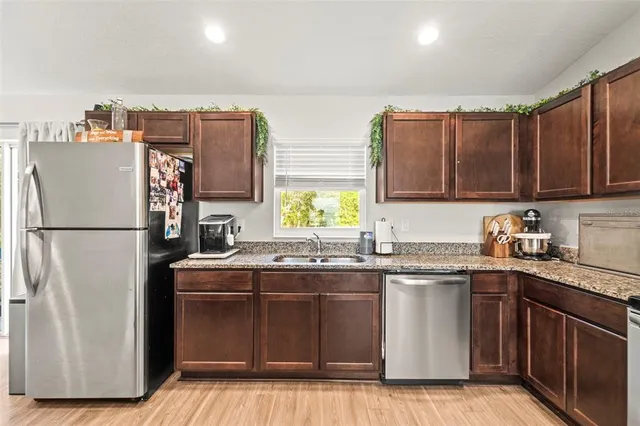 a kitchen with stainless steel appliances granite countertop wooden cabinets stove top oven and sink