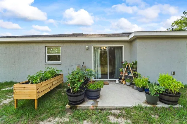 front view of a house with potted plants and a bench