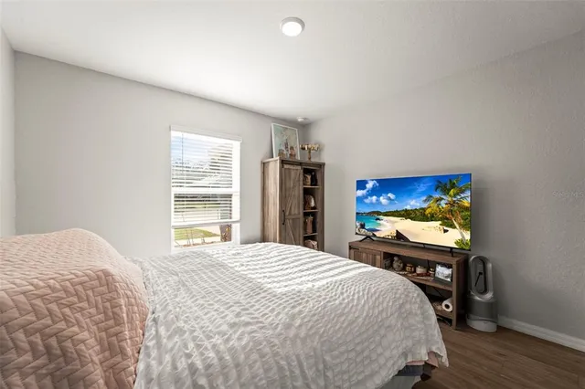a bedroom with a bed and a flat screen tv