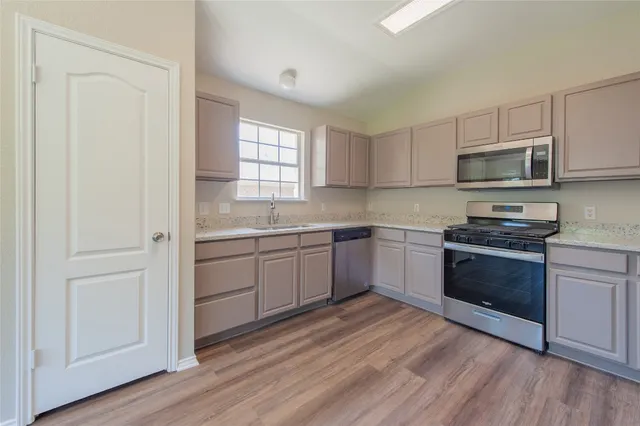 a kitchen with a sink cabinets and stainless steel appliances