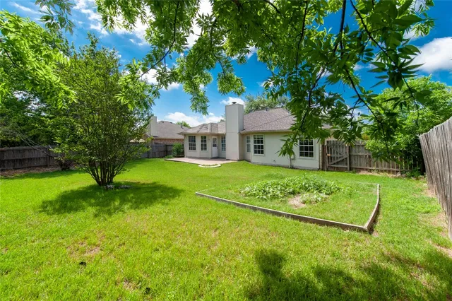 a view of an house with backyard and a tree
