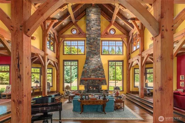 a view of a dining room with furniture a chandelier and large windows
