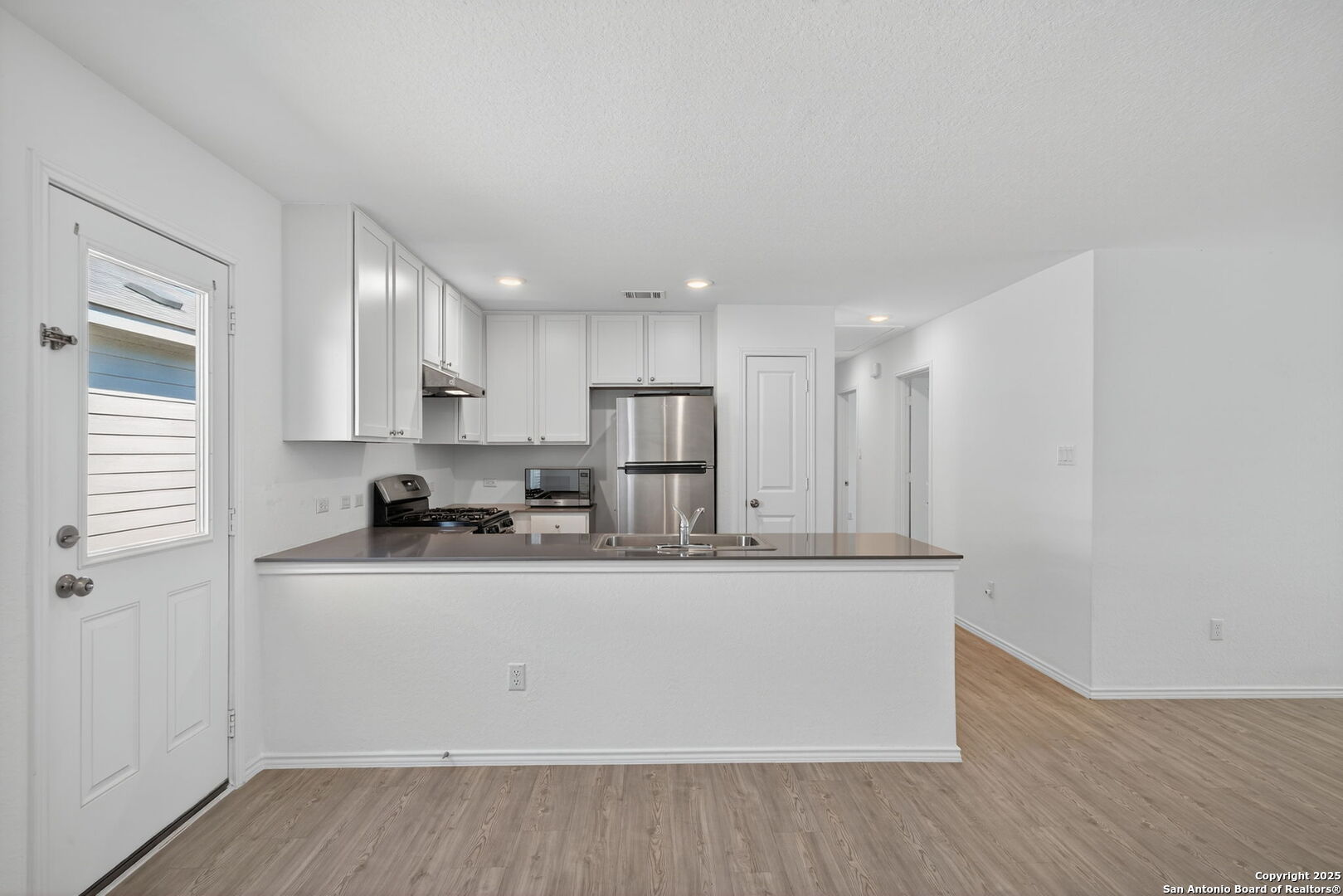 12935 Deep Eddy St. Hedwig, TX 78152 - Photo 13 of 26 a kitchen with stainless steel appliances granite countertop a sink a stove and a refrigerator