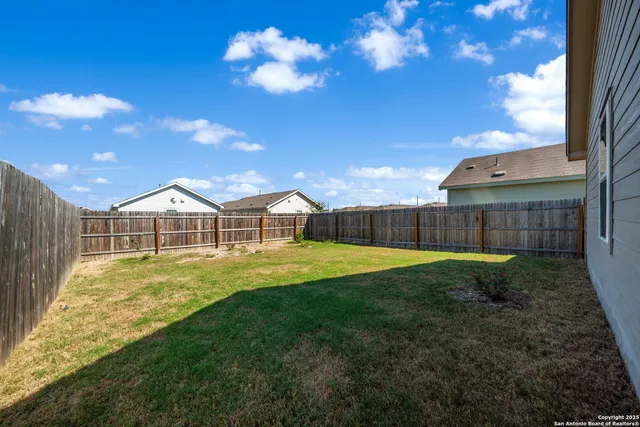 a view of a house with a backyard and a tree