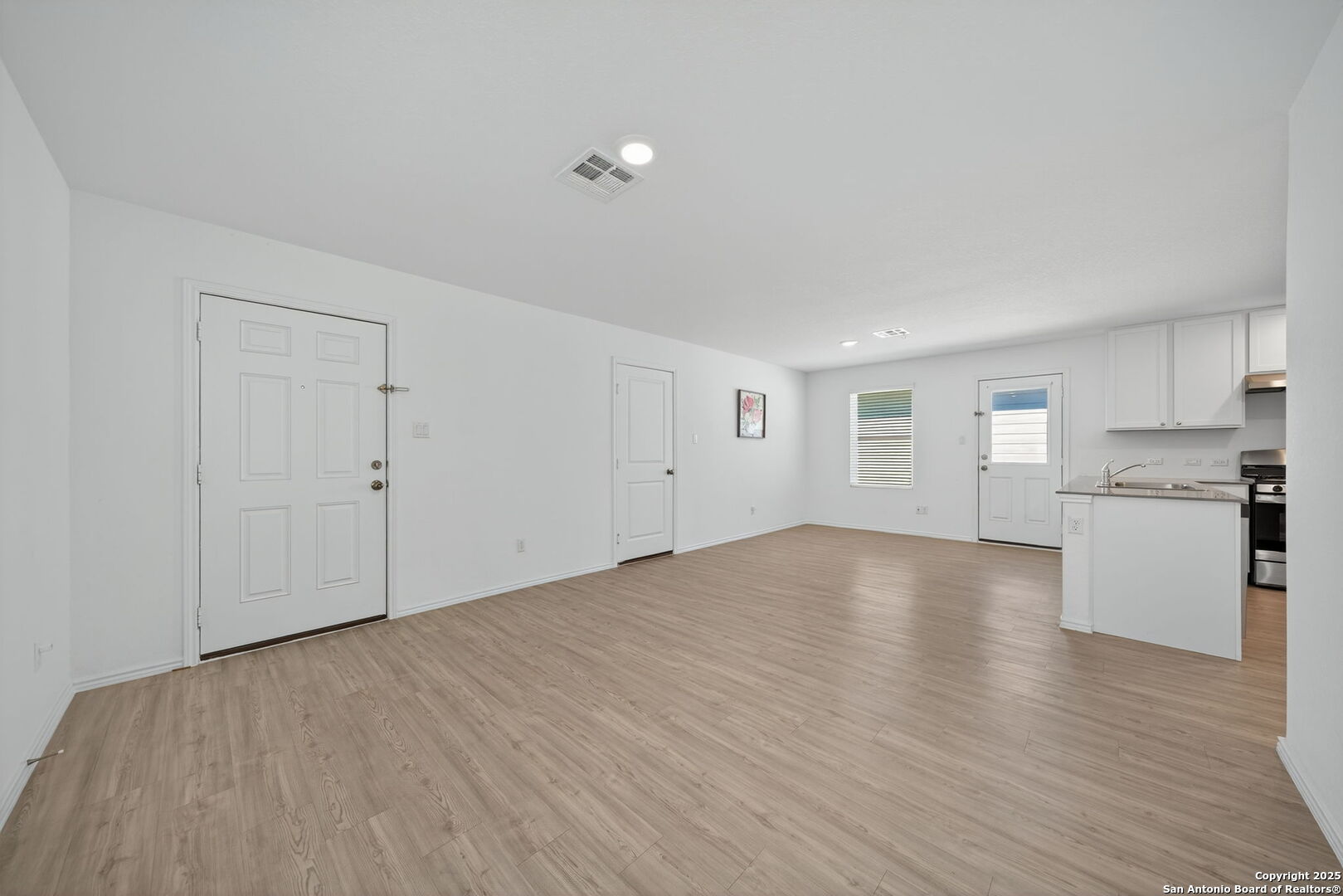 12935 Deep Eddy St. Hedwig, TX 78152 - Photo 8 of 26 a view of empty room with wooden floor and kitchen