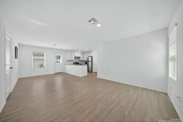 a view of empty room with wooden floor and window