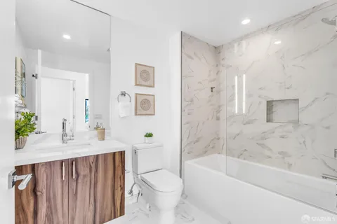 a bathroom with a bathtub shower sink and toilet