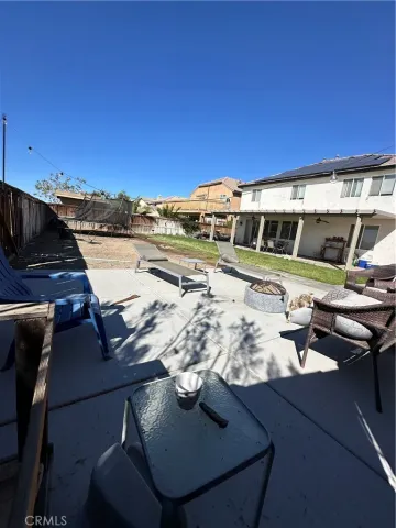 a view of a patio with a table and chairs under an umbrella
