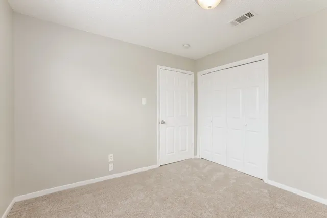 a view of an empty room and closet area