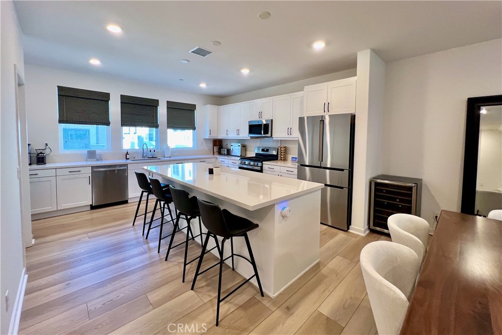 717 South Grable Circle Orange, CA 92868 - Photo 4 of 60 a kitchen with stainless steel appliances a dining table chairs refrigerator sink and microwave