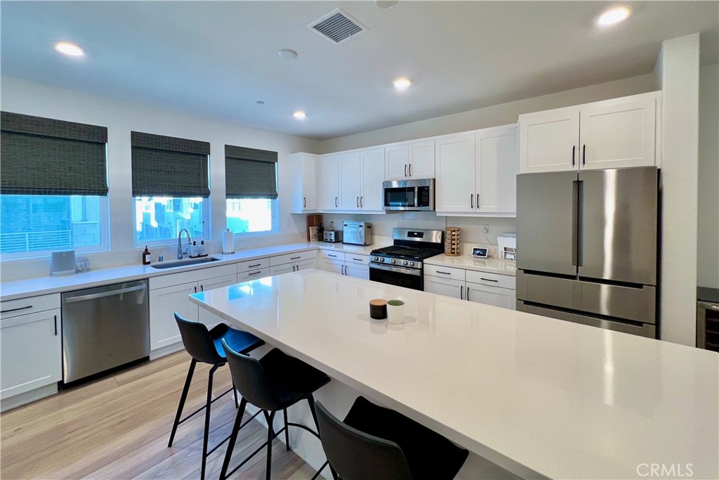 717 South Grable Circle Orange, CA 92868 - Photo 5 of 60 a kitchen with stainless steel appliances a refrigerator a stove a sink a dining table and chairs
