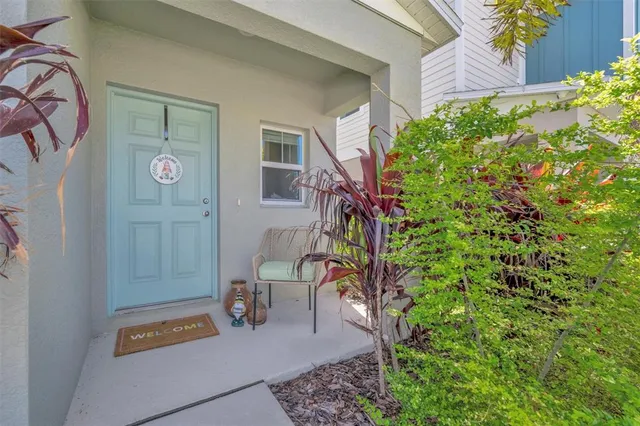 a balcony with table and chairs and potted plants