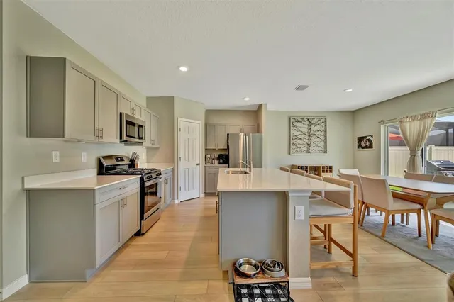 a kitchen with stainless steel appliances granite countertop a stove top oven a sink dishwasher and a refrigerator