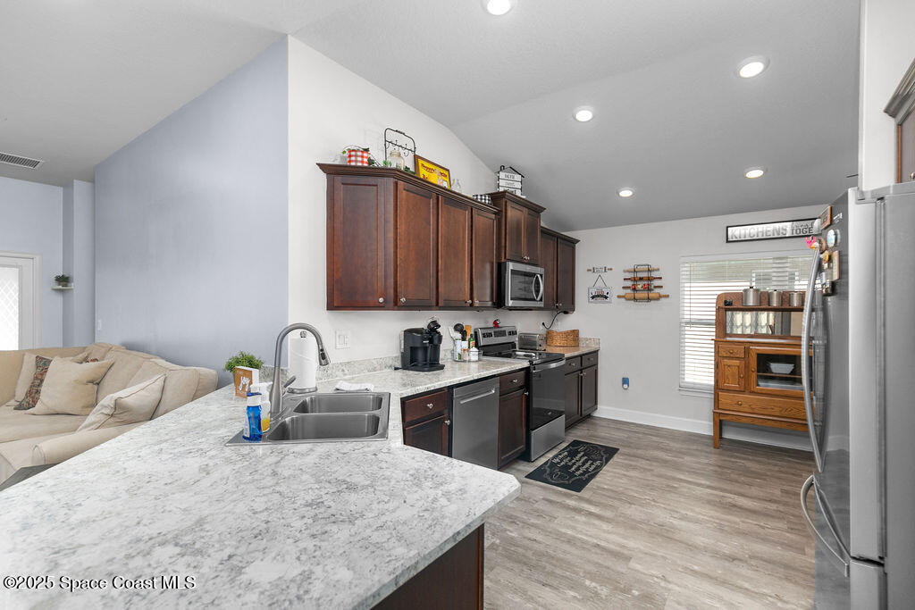 711 Tupelo Circle Cocoa, FL 32926 - Photo 11 of 47 a kitchen with stainless steel appliances granite countertop a refrigerator sink and cabinets