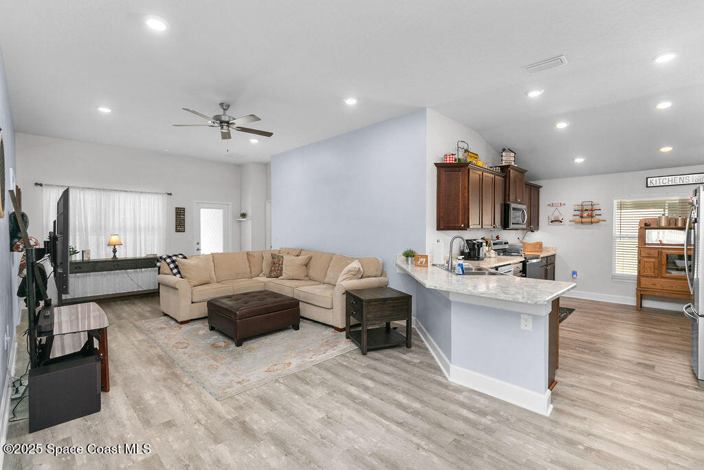 711 Tupelo Circle Cocoa, FL 32926 - Photo 15 of 47 a living room with furniture kitchen view and a chandelier