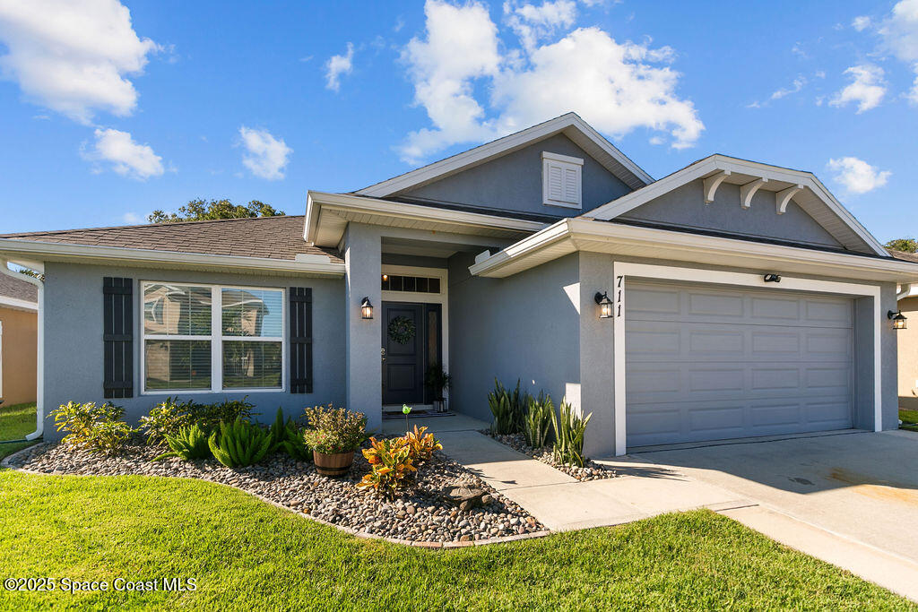 711 Tupelo Circle Cocoa, FL 32926 - Photo 2 of 47 a view of a white house with a small yard and potted plants