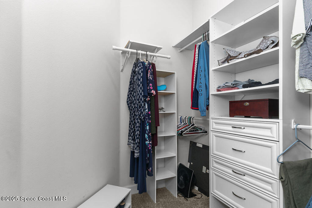 711 Tupelo Circle Cocoa, FL 32926 - Photo 22 of 47 a view of walk in closet with clothes and shoes