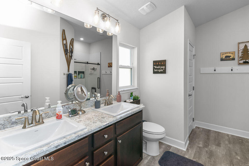 711 Tupelo Circle Cocoa, FL 32926 - Photo 23 of 47 a bathroom with a granite countertop sink toilet a large mirror a and shower