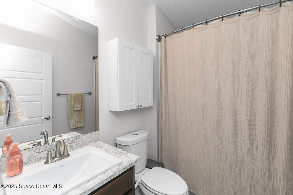711 Tupelo Circle Cocoa, FL 32926 - Photo 32 of 47 a bathroom with a sink a toilet and shower curtain