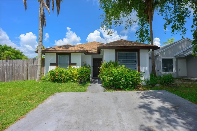 a view of a house with a yard and potted plants
