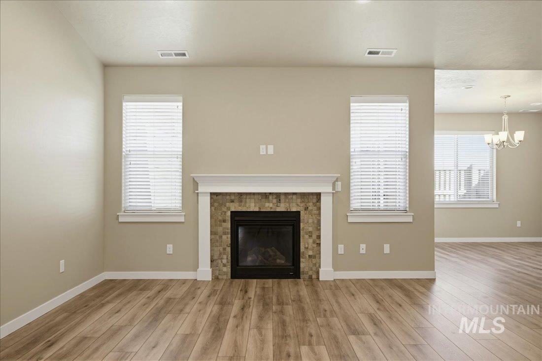 12460 West Azure Street Boise, ID 83713 - Photo 8 of 34 Living area featuring a fireplace with a mosaic tile surround, white mantel, and wood-finish flooring