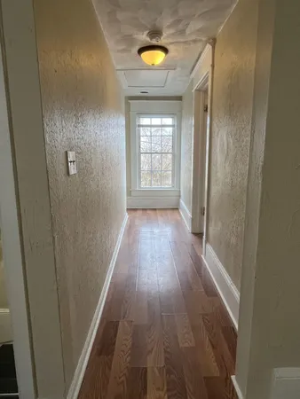 a view of hallway with wooden floor