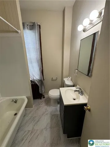 a bathroom with a tub sink and mirror